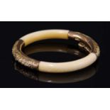 An early 20th century Chinese carved ivory and gold-mounted hinged bangle,