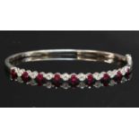 A white gold ruby and diamond hinged bangle,