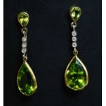 A pair of 18ct yellow and white gold peridot and diamond drop earrings,