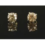 A pair of white gold, single stone diamond stud earrings,