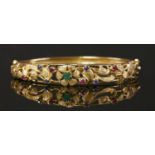 A 9ct gold emerald, ruby and sapphire set hinged bangle, c.1970,