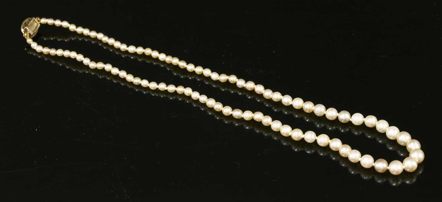 A single row uniform pearl necklace with a diamond set box clasp,