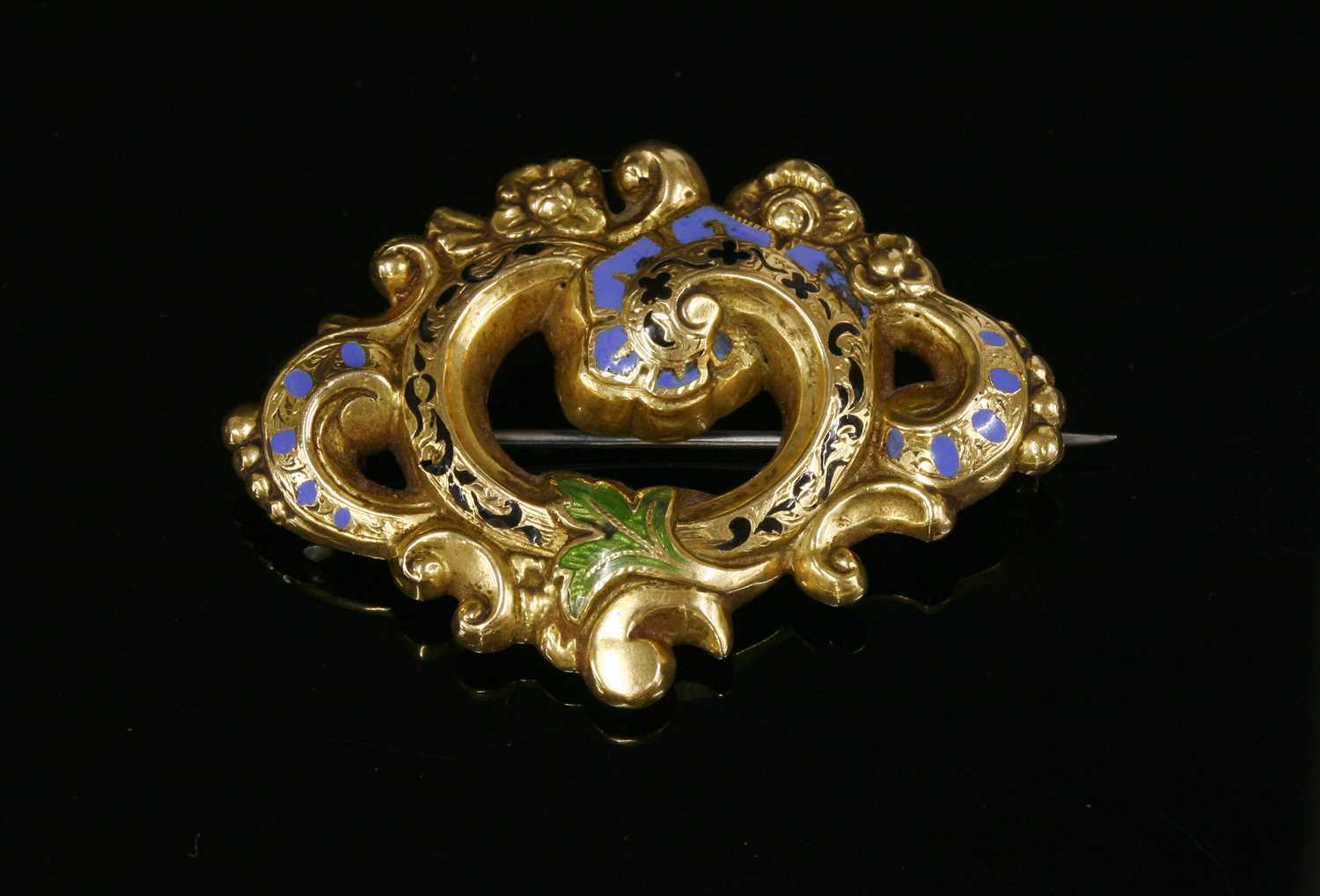 A Victorian gold and enamel scrolling foliate brooch,