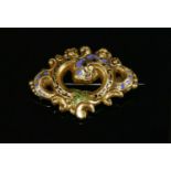 A Victorian gold and enamel scrolling foliate brooch,