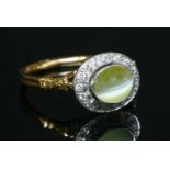 An 18ct yellow and white gold chrysoberyl cat's eye and diamond oval cluster ring,