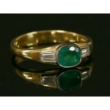 An 18ct gold emerald and diamond three stone ring,