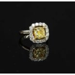 A white gold fancy yellow and white diamond cushion-shaped halo cluster ring,