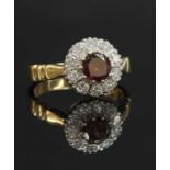 An 18ct gold garnet and diamond circular cluster ring,