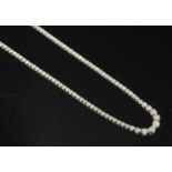 A white gold diamond set graduated rivière necklace,