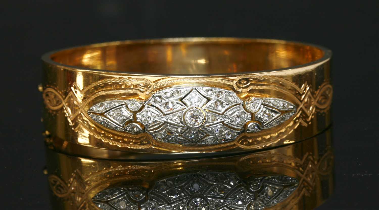 A French diamond set platinum and gold hinged bangle,