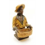 A polychrome decorated figure of a boy with a basket,