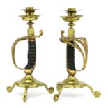 A pair of brass sword hilt candlesticks,