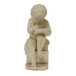 A carved alabaster figure of a young boy writing,