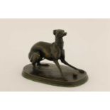 A bronze model of a whippet with a ball,