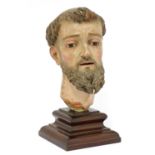 A Spanish carved wood and polychrome head of a saint,