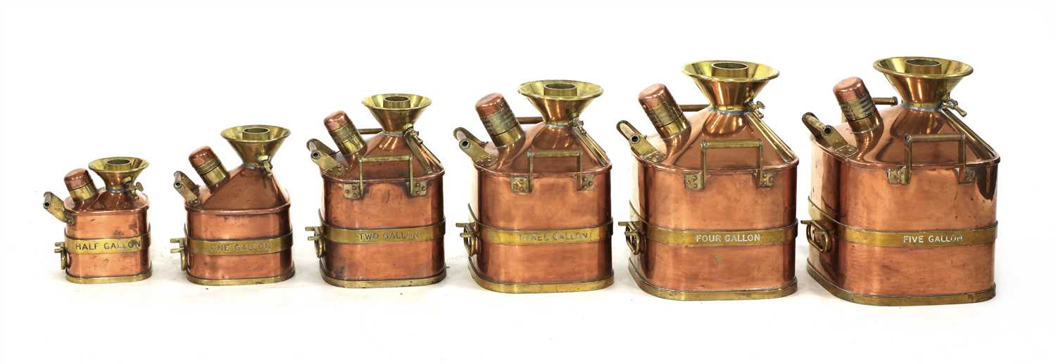 A complete set of six graduated copper and brass banded petrol 'standard' measures,