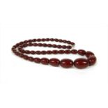 A single row graduated cherry coloured olive shaped Bakelite bead necklace,