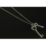 A platinum and 18ct white gold diamond set heart double key pendant, by Tiffany & Co,