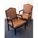 A pair of Louis XV style upholstered stained pine open-armed fauteuil; moulded shaped arms,