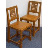 An opposing pair of Robert 'Mouseman' Thompson (Kilburn oak and leather-upholstered side chairs),