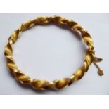 A Continental yellow metal barley-twist bangle, approx. 21.