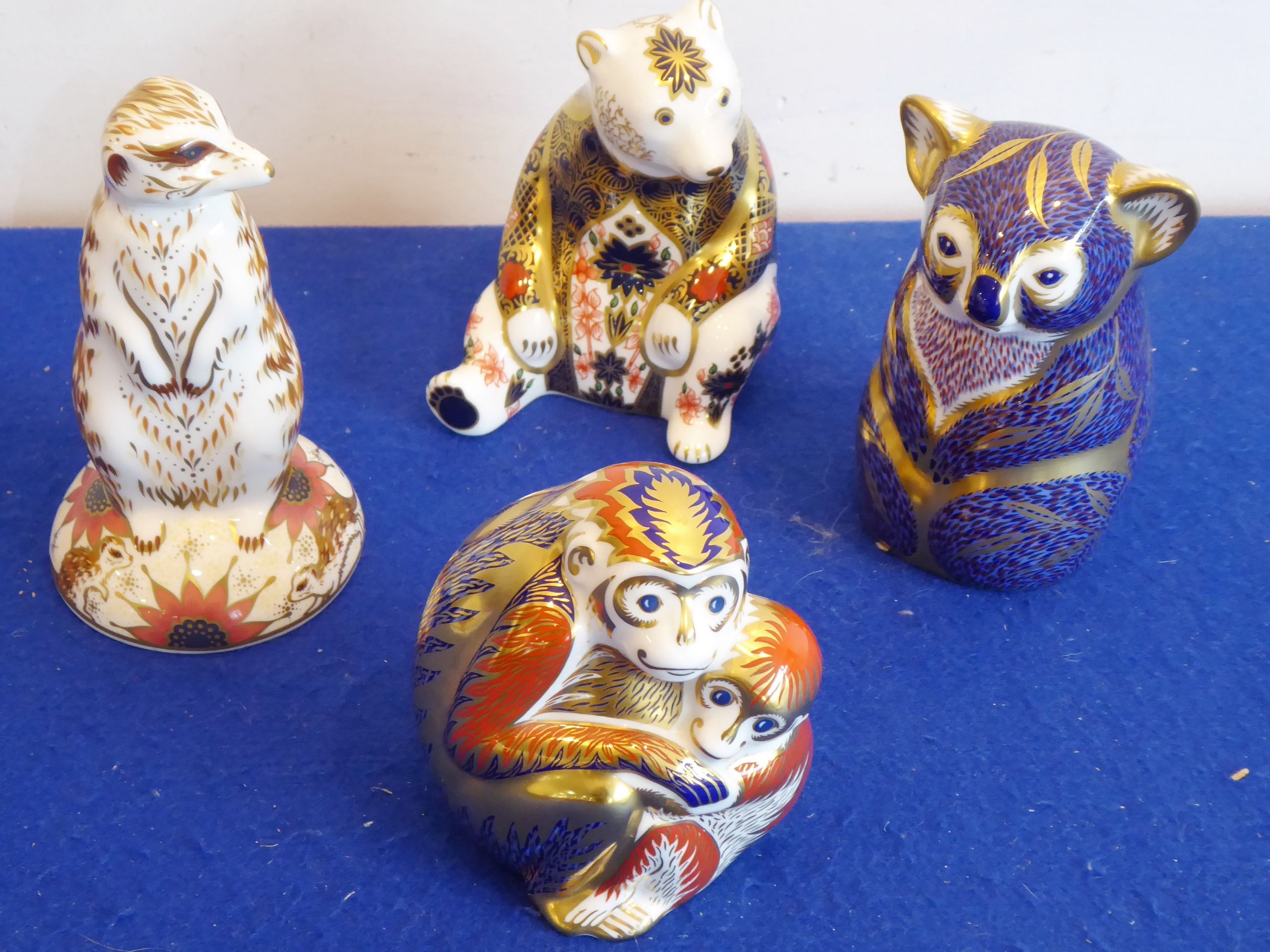 Four Royal Crown Derby paperweights: a meerkat, a seated bear,