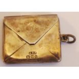 An early-20th century hallmarked silver stamp case in the form of an envelope with hinged flap;