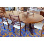 An extending Danish rosewood dining table having two extra leaves together with a set of six