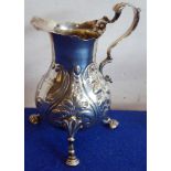 A mid-18th century hallmarked silver baluster-shaped cream jug with later repoussé-style decoration,