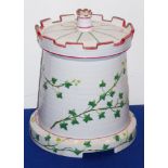 A 19th century ceramic stilton dish and cover modelled as a castellated turret with trailing ivory;