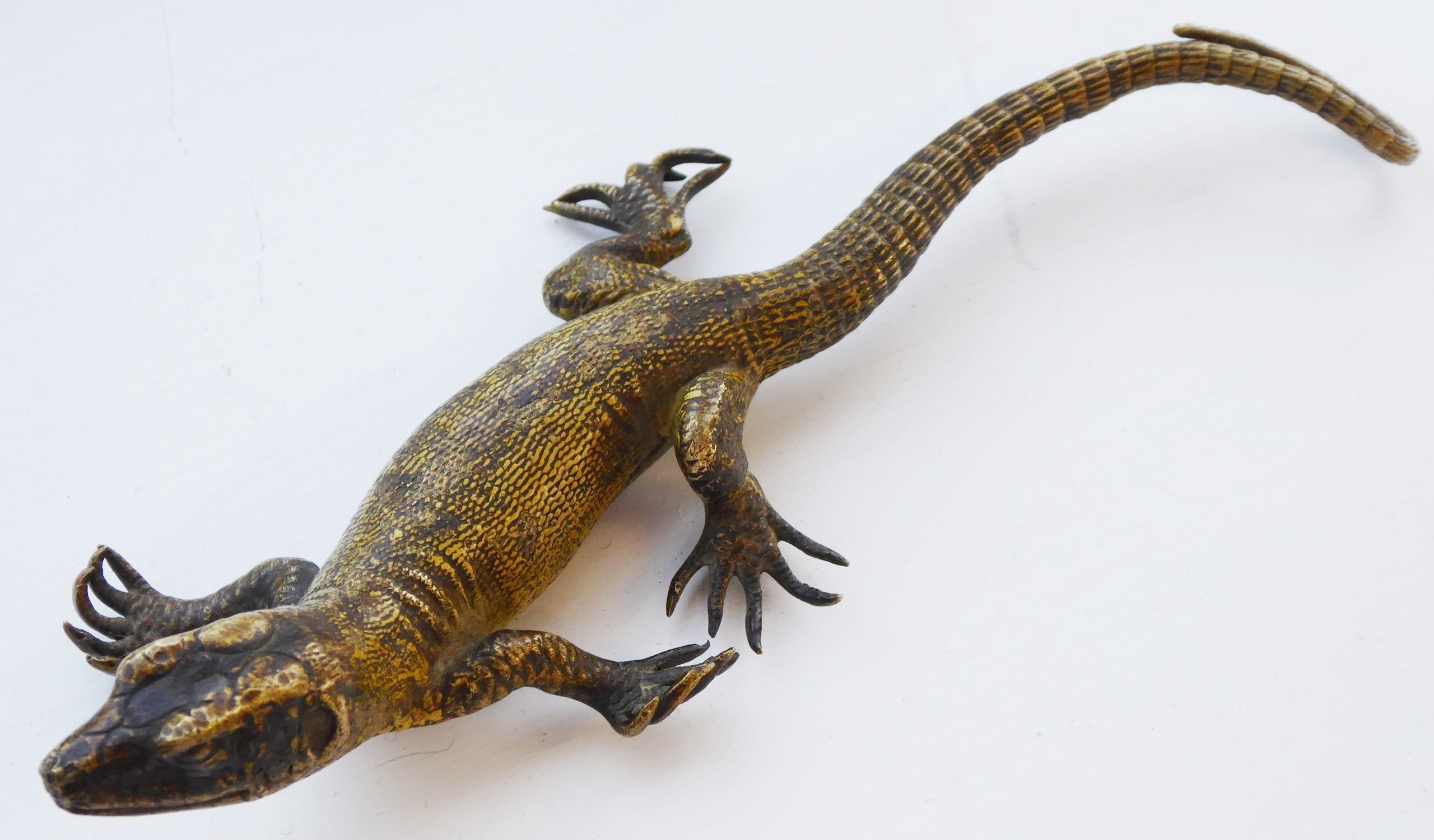 An early 20th century cold-painted bronze model of a lizard with yellow scaly skin;