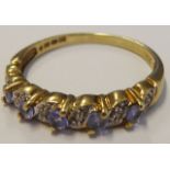 A 9-carat yellow gold dress ring horizontally set with five hand-cut light-purple-coloured stones