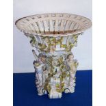 A Continental figural porcelain centrepiece modelled as a reticulated basket;