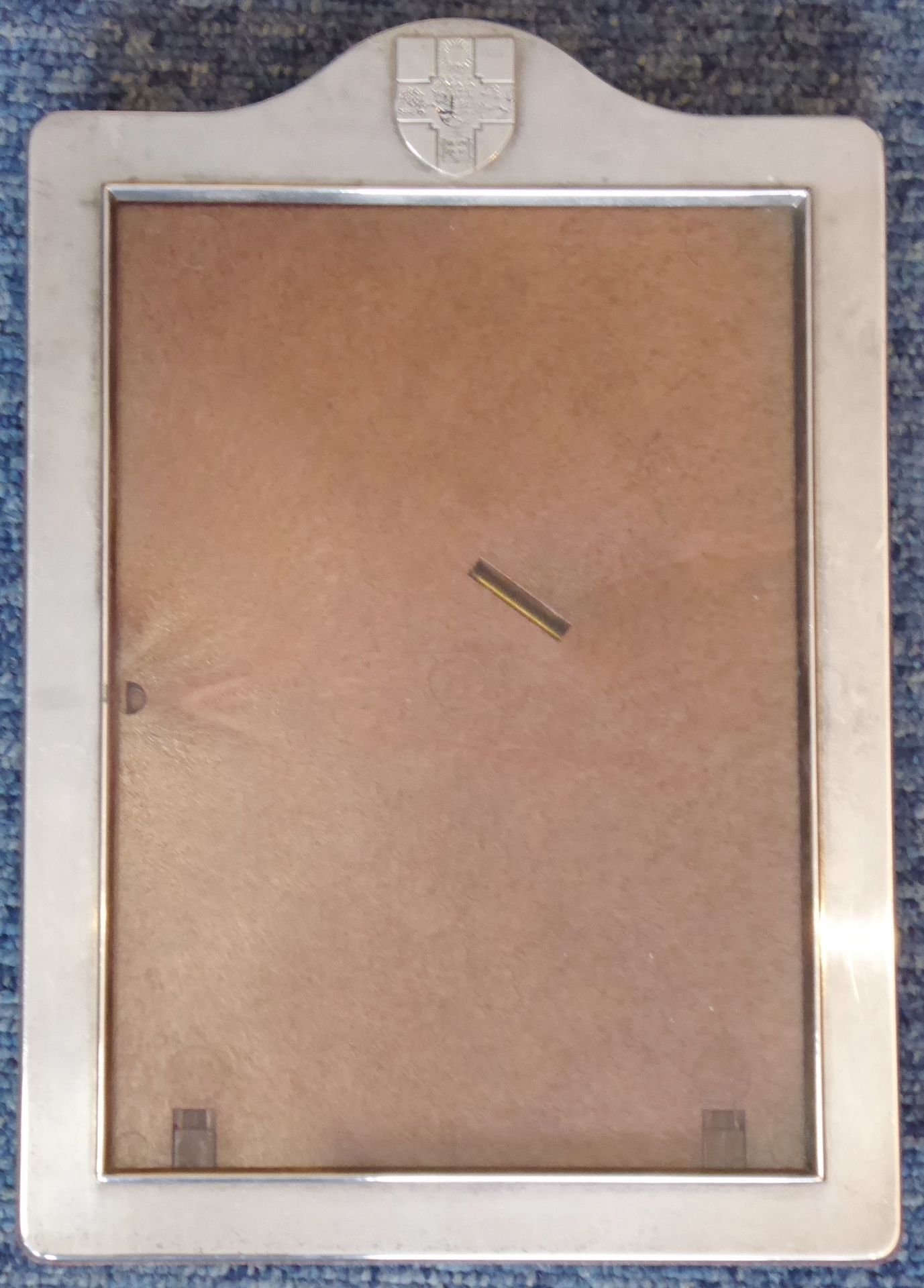 A modern hallmarked silver (marked 925) photograph frame with shield-shaped crest surmounting,