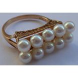 A yellow metal (marked 14k) dress ring centrally set with two horizontal bands of five pearls