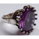 A white metal and single round amethyst claw-set ring