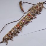 An Indian yellow metal fringe necklace set with a multitude of semi precious stones and coral etc.