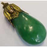 An early 20th century gilt-metal-mounted pear-shaped pendant set with a cold green hardstone