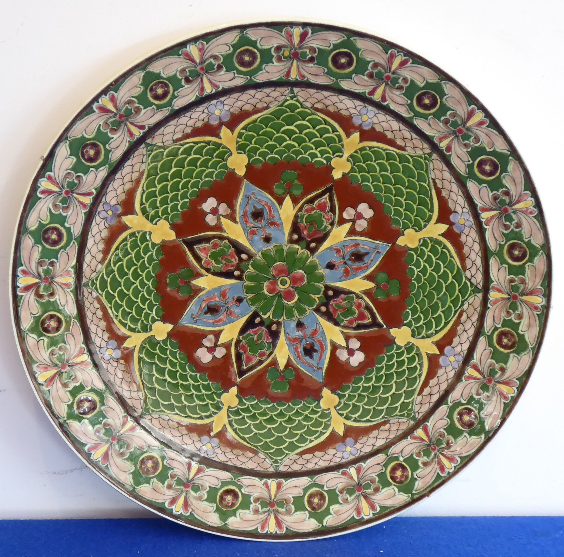 An early 20th century Royal Bonn 'Old Dutch' pattern wall hanging charger hand-decorated in enamels,