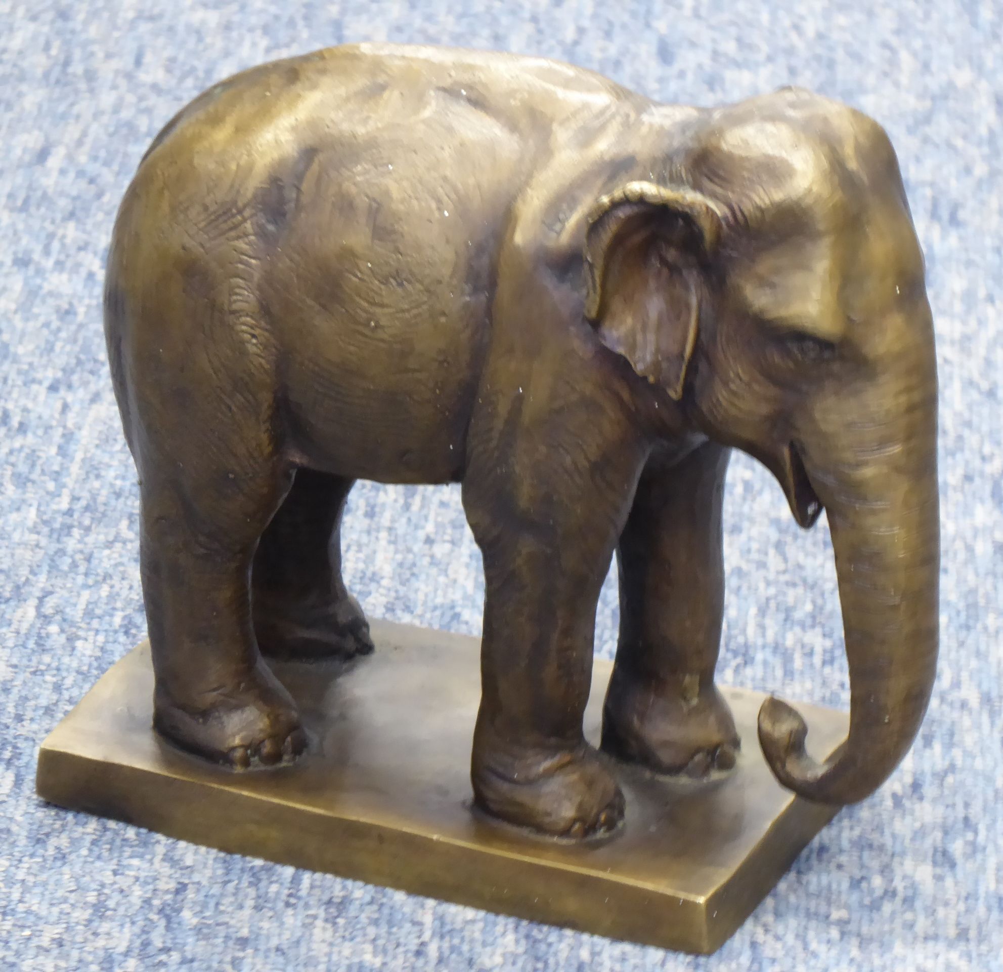 A cast bronze elephant standing four square (modern), raised on plinth base, 20cm long x 18.