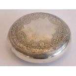 An early-20th century circular silver box with spring-loaded hinge cover, gilded interior, vacant