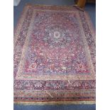 A large hand-knotted Persian Heriz-style carpet central flower-head pattern with a blue border