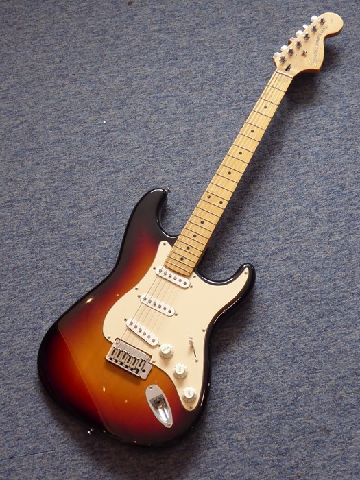 A Squier Stratocaster (by Fender) six-string 20th anniversary issue electric guitar in sunburst,