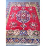 A large and heavy hand-knotted woollen Persian carpet, the central blue ground lozenge surrounded by