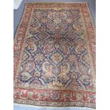 A large mid-20th century hand-knotted Persian woollen carpet central blue ground rectangle with a