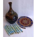 A large Gouda Pottery vase of bottle form hand decorated and gilded with various flower heads