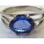 A hallmarked platinum single-sapphire ring; the oval cornflower-blue sapphire (approx. 6.4mm x 8.