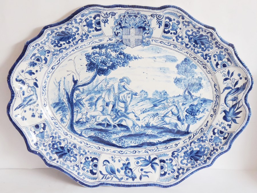 A 19th century Continental Faience platter of oval form with scallop edges, hand decorated with an