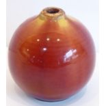 A 19th century Linthorpe pottery vase; of spherical form and with red and mustard trailing glazes,