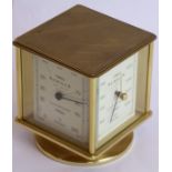 A heavy gilt-metal and glass-sided revolving timepiece, barometer, hygrometer and thermometer